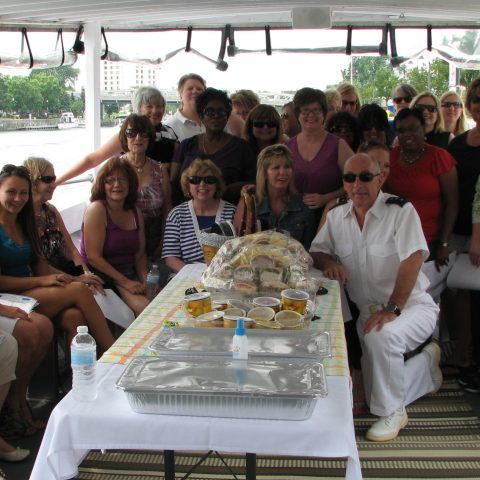 a group of people sitting at a table with a cake