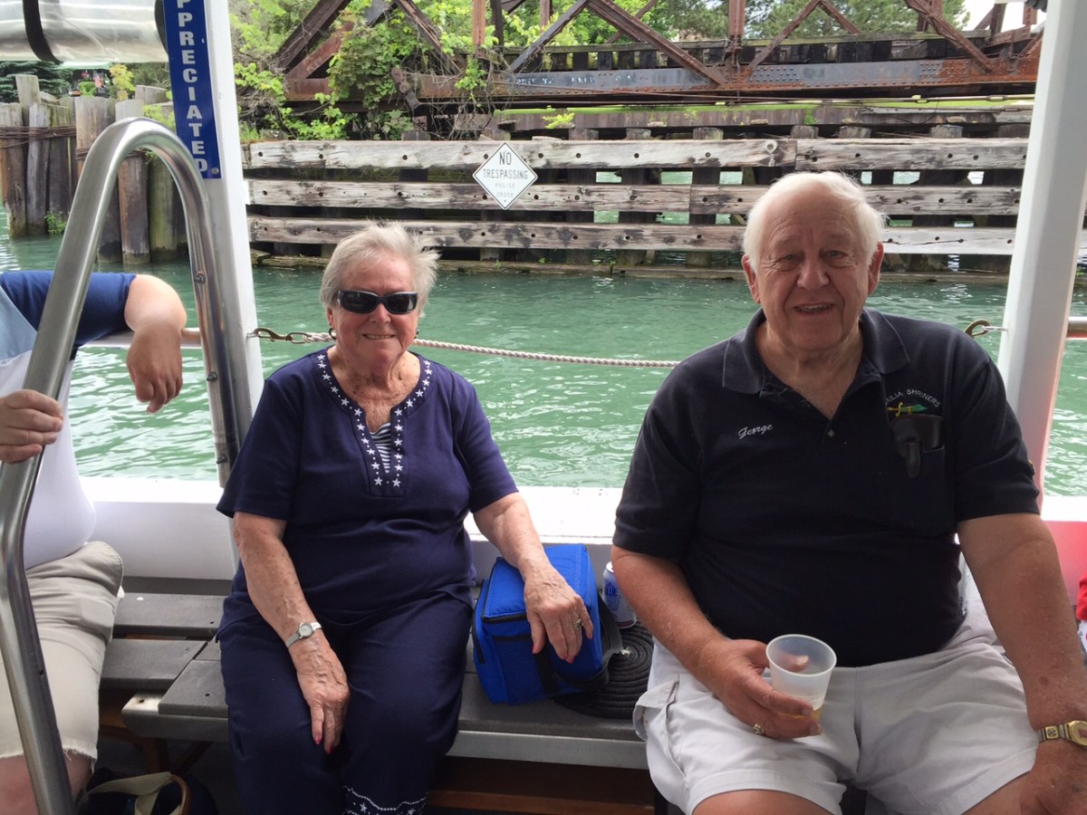 a man and a woman sitting on a bench posing for the camera