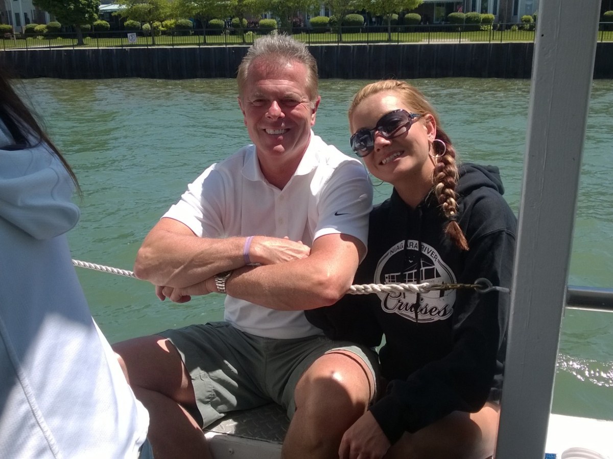 a man and woman sitting next to a body of water