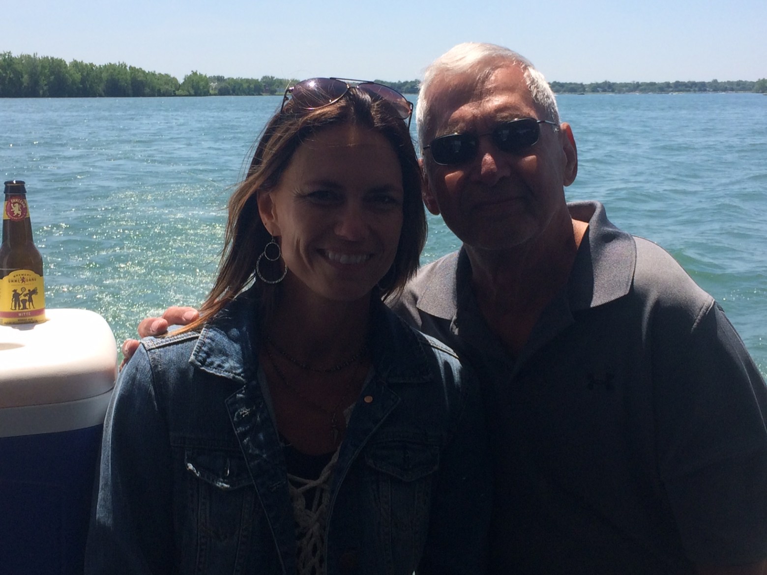 a man and a woman standing in front of a body of water