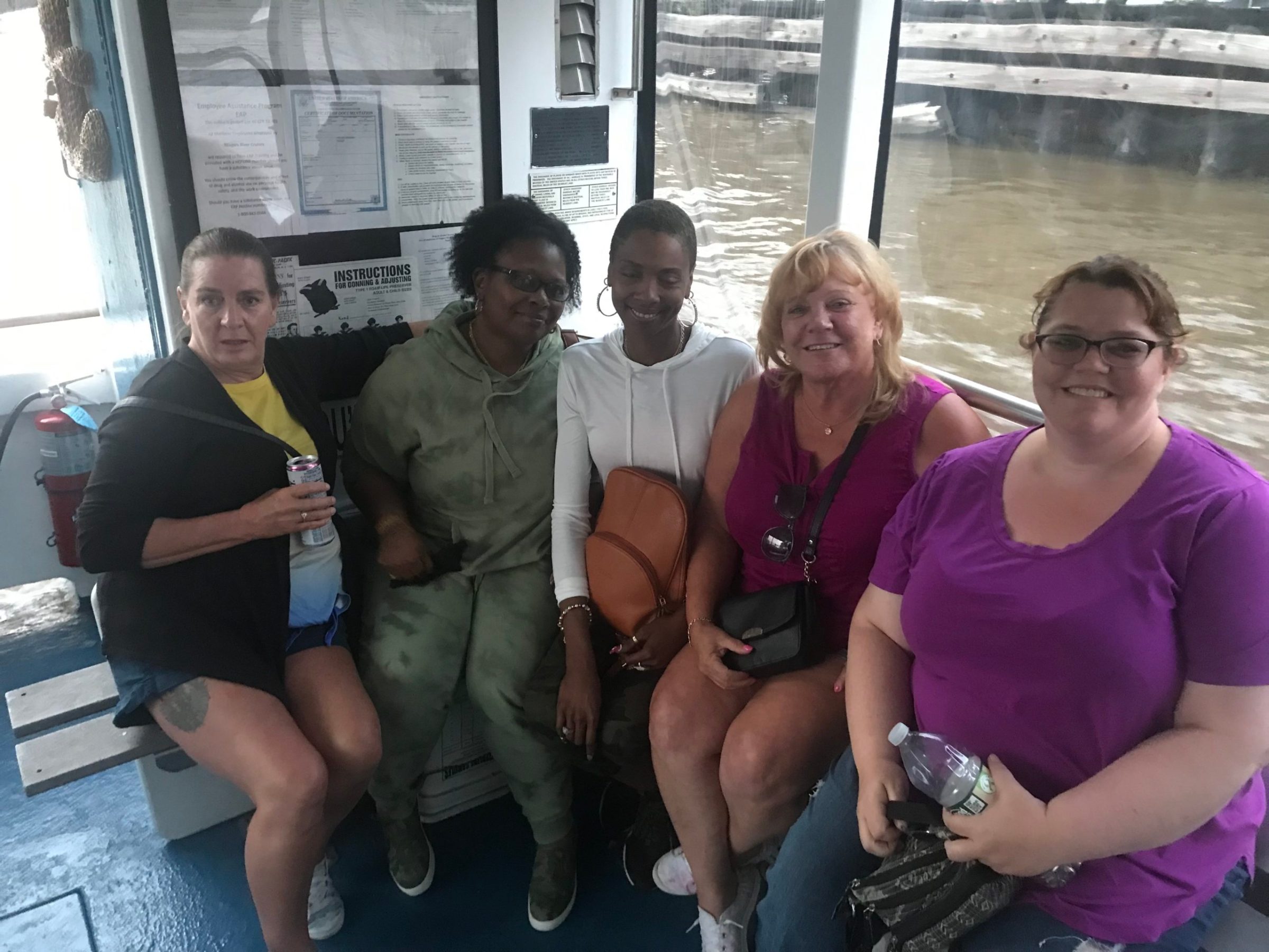 a group of people sitting on a bench posing for the camera